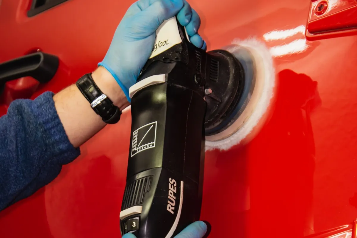 Polissage d'une carrosserie rouge à la machine